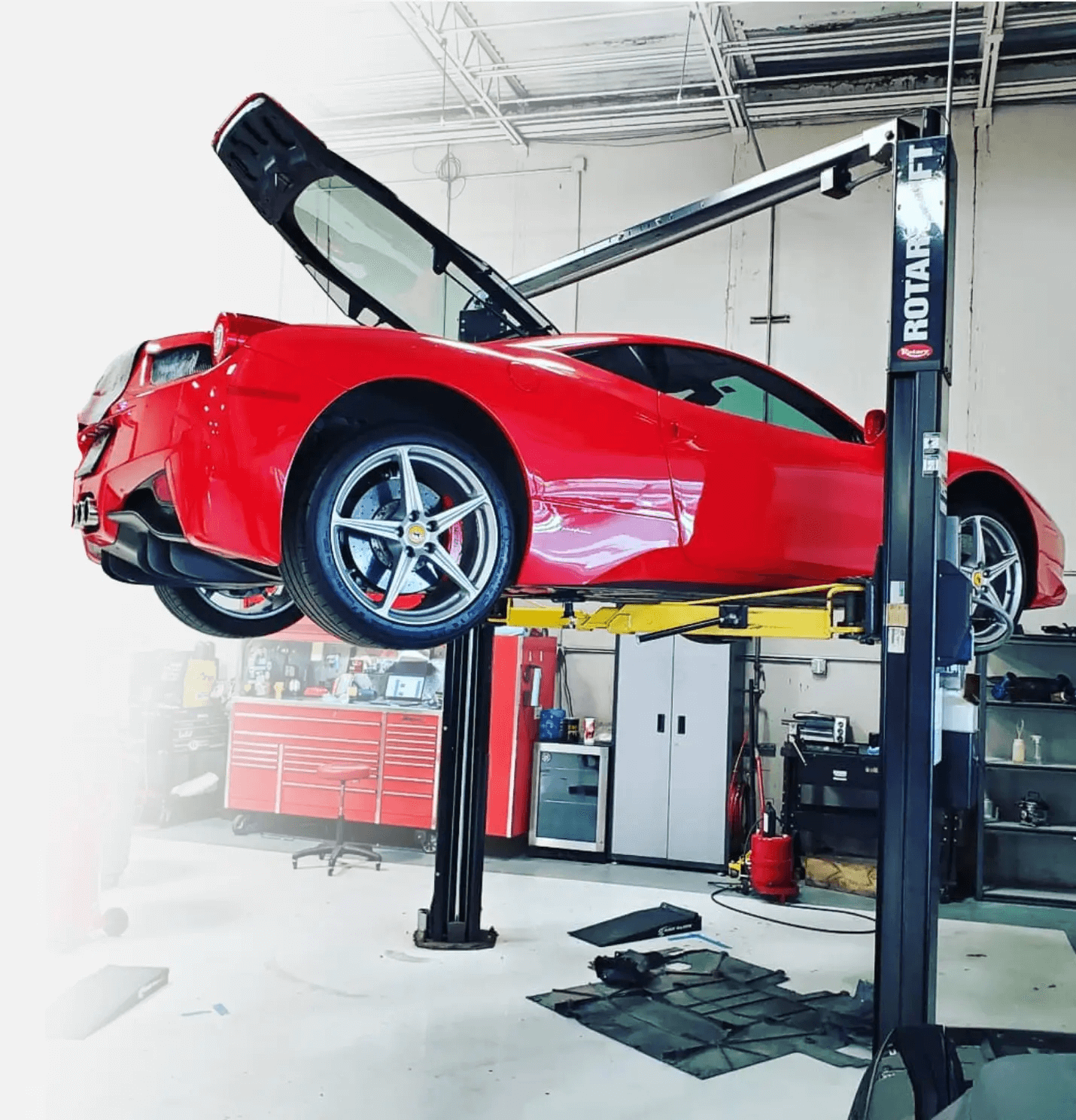 Red Ferrari Car On A Lift In Our Garage